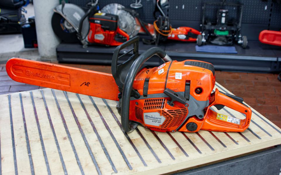 Husqvarna Motorsäge auf Werkbank im Verleihbereich – professionelle Kettensäge für Forst- und Gartenarbeiten.