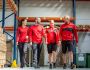 Team in Arbeitskleidung bei einem Rundgang durch das Lager – moderne Berufsbekleidung für Industrie, Logistik und Handwerk.